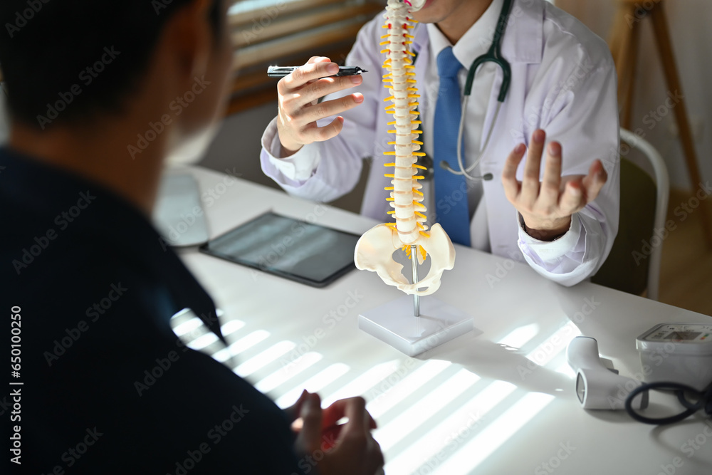 Obraz premium Orthopedist giving consultation about scoliosis or spinal problems to patient during medical exam. Healthcare concept