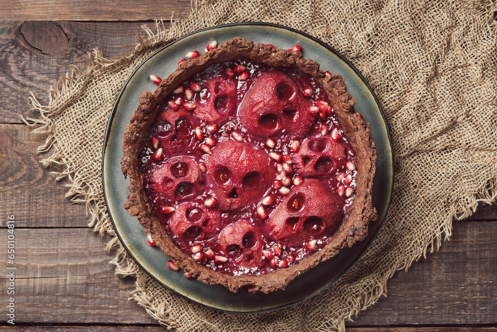 Halloween food. Homemade pie with jam and scary skull-shaped pears. Creative treat for Halloween party. - obrazy, fototapety, plakaty 