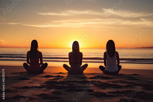 Women meditate in the lotus position on the beach at sunset  finding balance  health and tranquility.