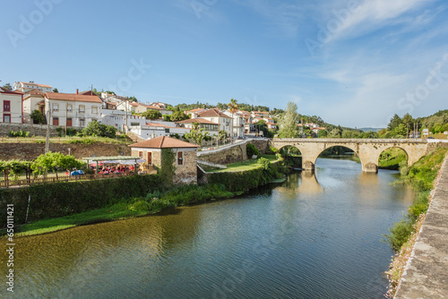 View of the beautiful picturesque Coja village in the Arganil region in Portugal, with its beautiful river and iconic bridge surrounded by the people's houses photo