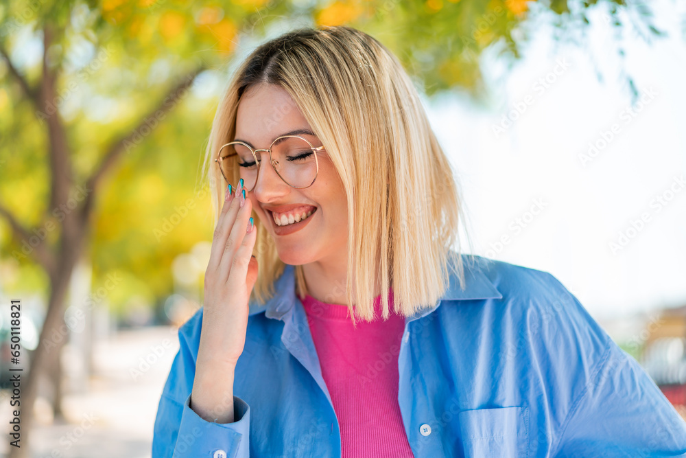 Young pretty woman with glasses at outdoors smiling a lot Young pretty woman with glasses at outdoors smiling a lot