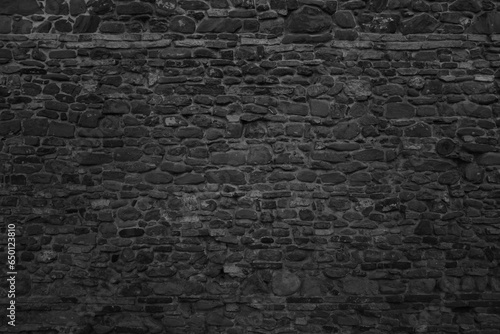 Old black stone wall texture. Dark background