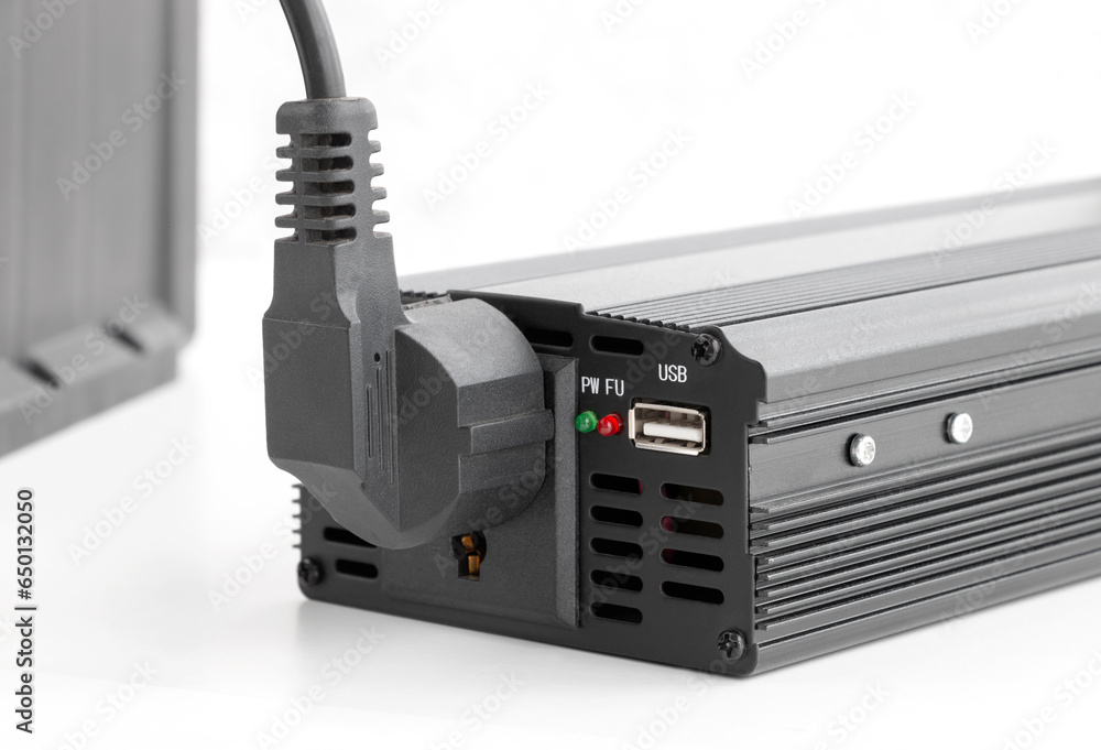 electrical equipment plug connected to Power Inverter, offline energy concept, DC 12V to AC 220v or 110v converter, close-up on isolated white, selective focus electrical equipment plug connected to Power Inverter, offline energy concept, DC 12V to AC 220v or 110v converter, close-up on isolated white, selective focus