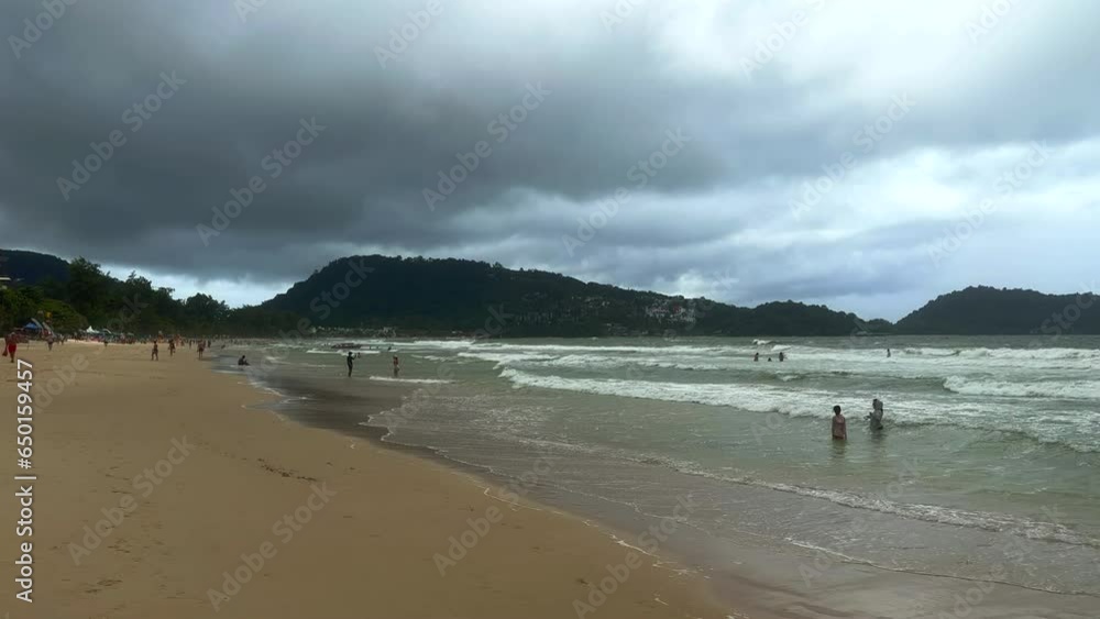 People at the beach. Cloudy day at the beach. Patong Beach, Phuket, Thailand People at the beach. Cloudy day at the beach. Patong Beach, Phuket, Thailand