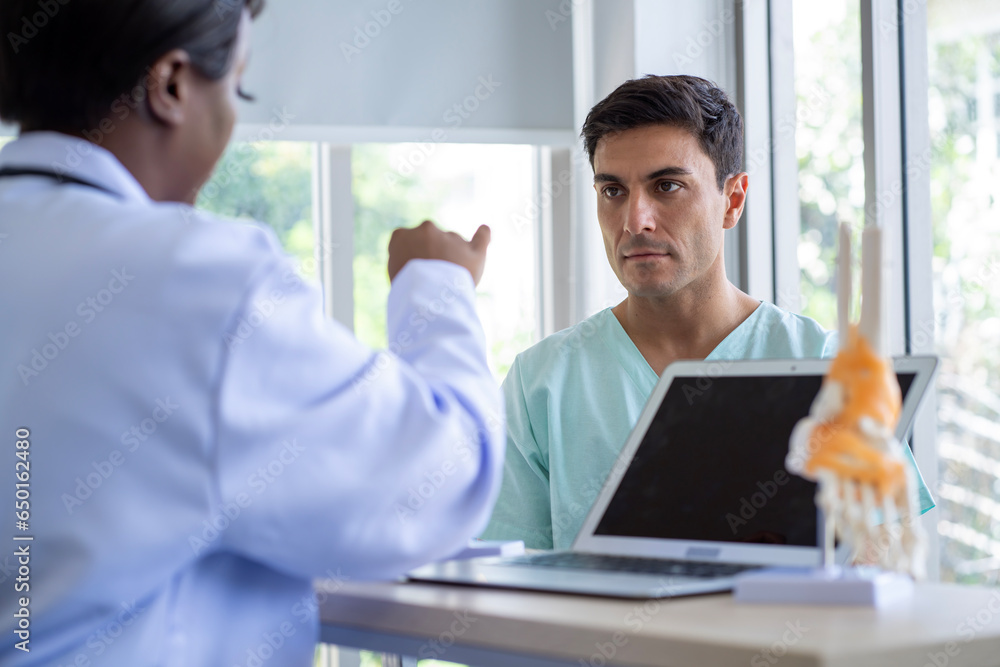 Female doctor and male patient Discuss and give advice about wrist and arm pain among patients in the hospital. Female doctor and male patient Discuss and give advice about wrist and arm pain among patients in the hospital.