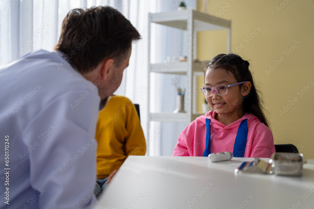 Obraz premium Male doctor and girl young patient Talk and give advice about your illness at the hospital.