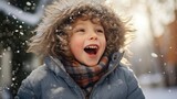 Happy kid wearing warm clothes plays outdoors with snow in winter. Christmas and New Year mood