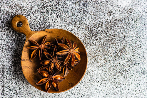 anise star spice for baking in wooden spoon on concrete table photo