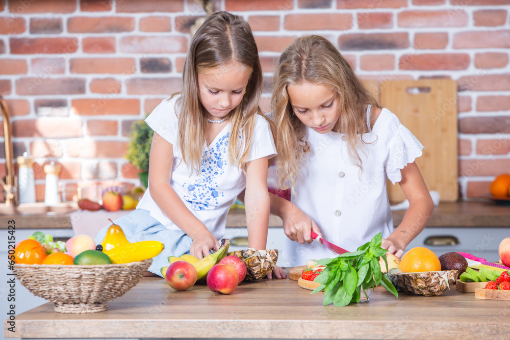 Two little girls in the kitchen with fresh vegetables. Healthy food concept. Happy sisters. Two little girls in the kitchen with fresh vegetables. Healthy food concept. Happy sisters.