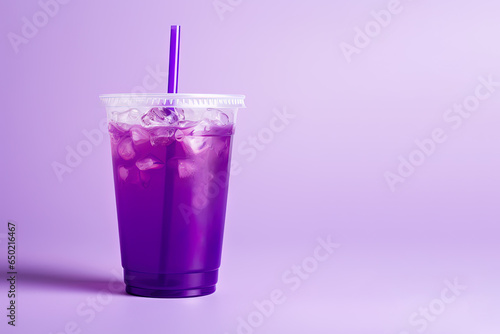 Purple drink in a plastic cup isolated on a purple background. Take away drinks concept with copy space