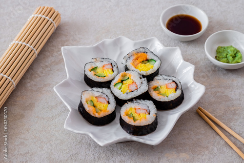 Maki sushi rolls on white plate with soy sauce and wasabi-Japanese food