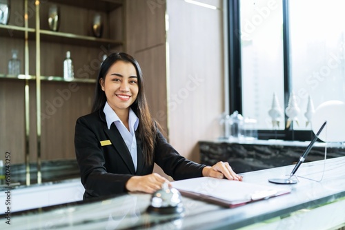 Beautiful asian hotel receptionist in  uniforms at desk in lobby Friendly and welcome staff in hotel reception counter. photo