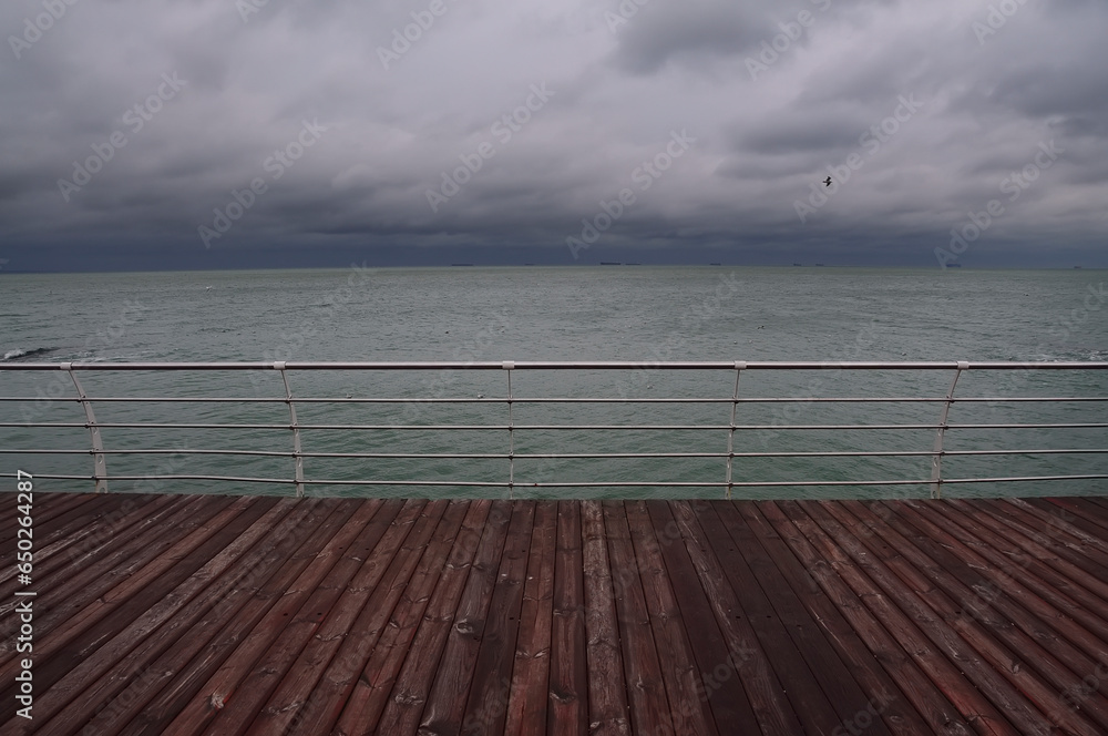   wooden jetty overlooking dramatic sky and sea.
