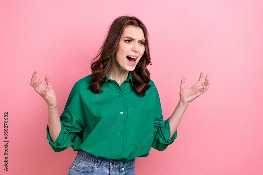 Photo of shocked mad woman dressed green shirt screaming empty space isolated pink color background Photo of shocked mad woman dressed green shirt screaming empty space isolated pink color background