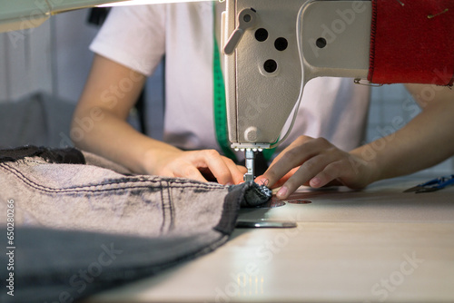 hands of a seamstress working for the machine .close up