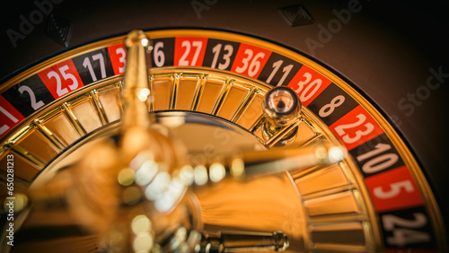 Glücksspiel Roulette mit Rouletterad im Casino an Roulettetisch mit Kugel auf einer roten Zahl