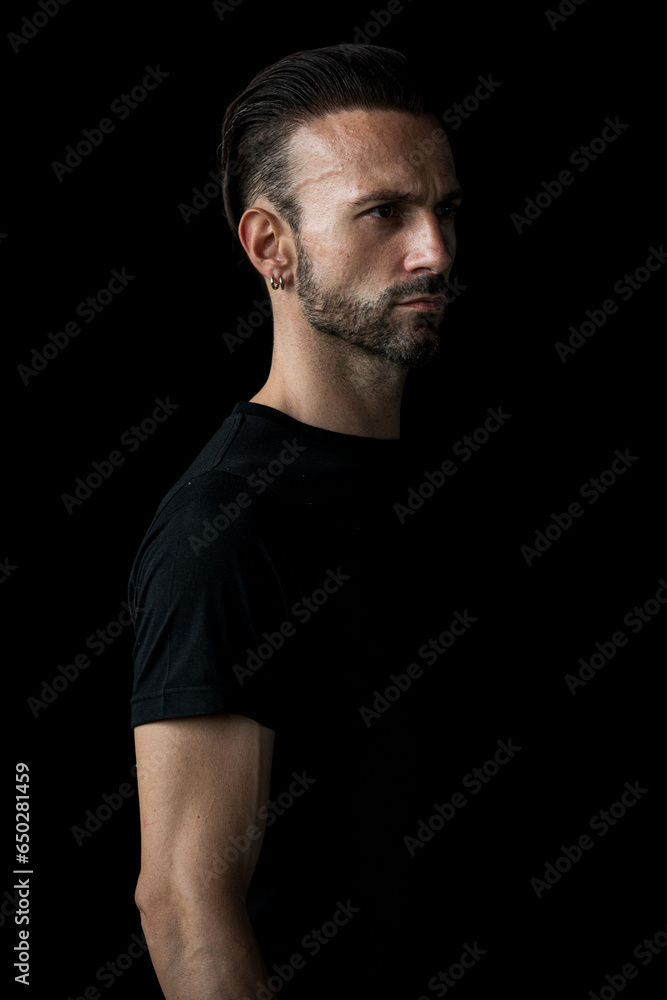 Portrait of bearded man against black background