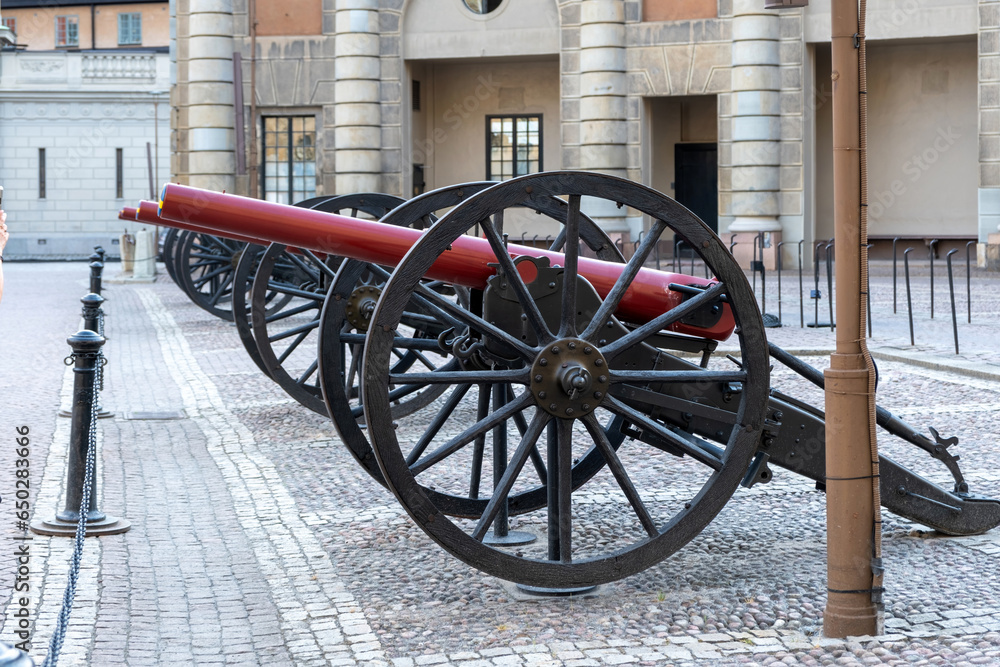Three cannon at Royal Palace in Gamla Stan Stockholm Sweden. Old metal weapon on kingdom paved yard.