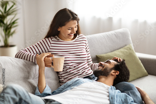 Sweet indian millennial couple cuddling at home, have conversation