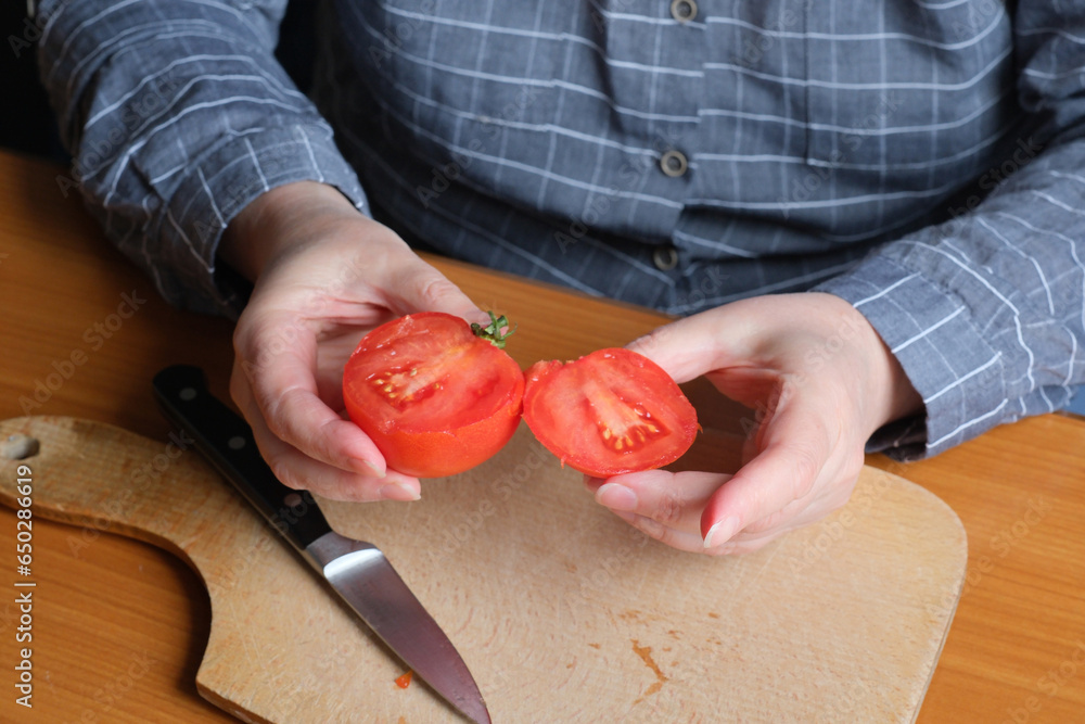 An elderly woman's hands hold a tomato An elderly woman's hands hold a tomato