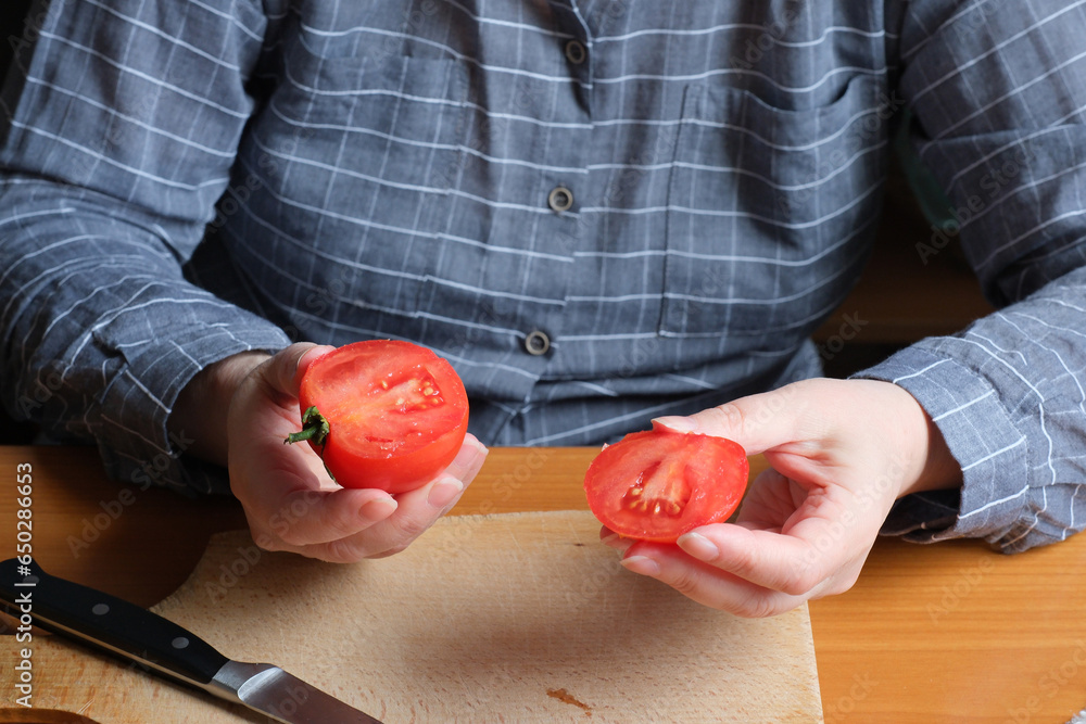 An elderly woman's hands hold a tomato An elderly woman's hands hold a tomato
