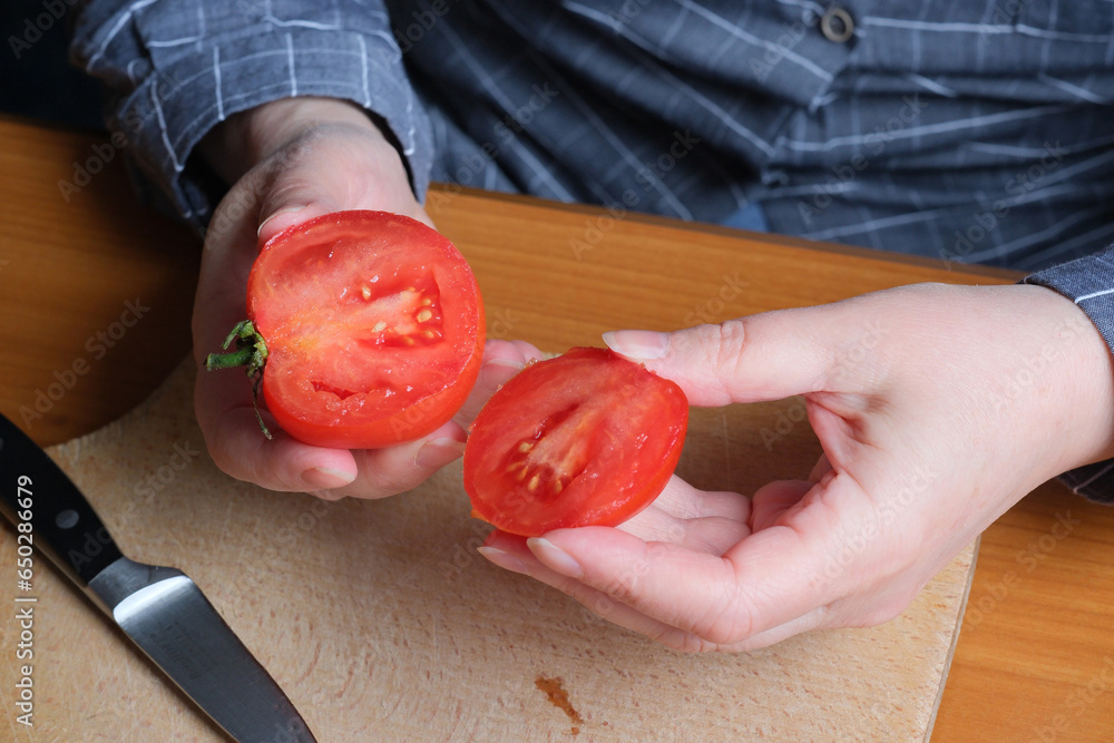 An elderly woman's hands hold a tomato An elderly woman's hands hold a tomato