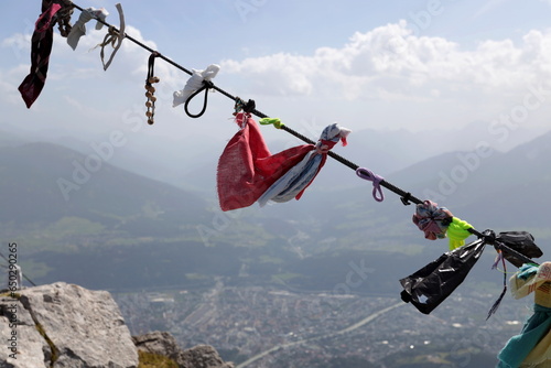 Handkerchiefs, bracelets and various objects left by tourists on the rope at the top of Innsbruck. Innsbruck seen from above. photo