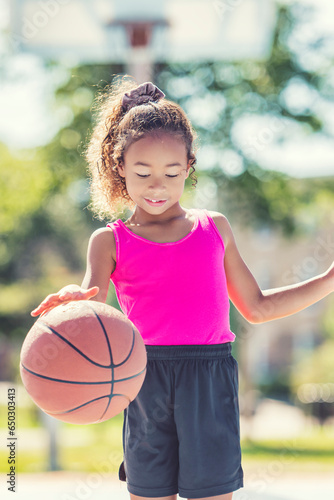 girl with basketball on court on summer season © Louis-Photo