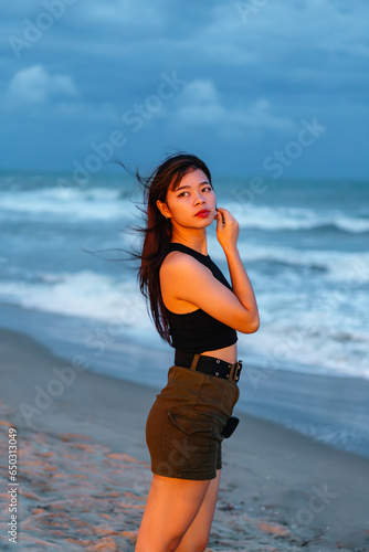 Fototapeta Naklejka Na Ścianę i Meble -  asian girl tourist woman standing at beach sea on travel vacation in nightlight, summer tropical travel holiday concept with copy space