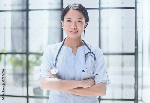 Portrait of asian female doctor looking at camera with arms crossed
