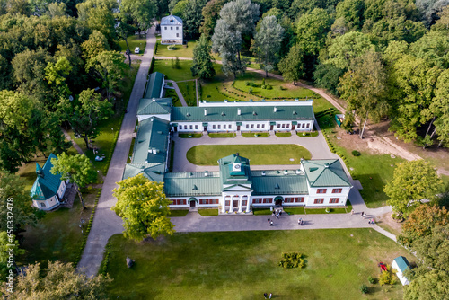 aerial view on overlooking restoration of the historic castle or palace in forest near lake or river photo