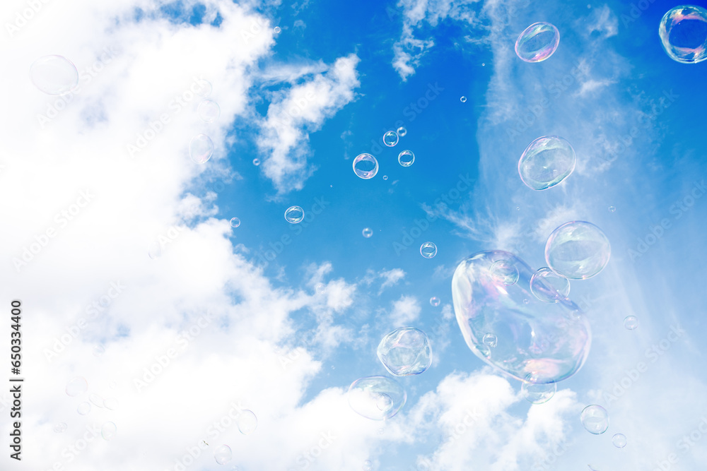 Soap multi-colored bubbles against a background of blue sky with clouds - obrazy, fototapety, plakaty 