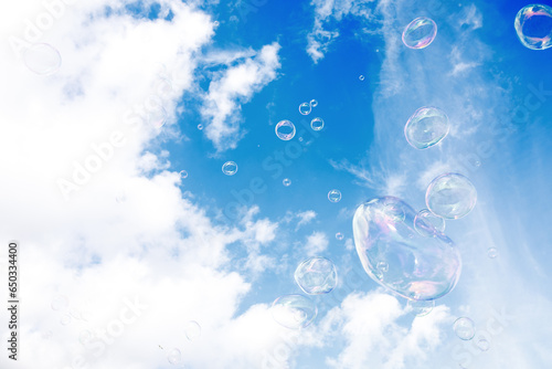 Soap multi-colored bubbles against a background of blue sky with clouds