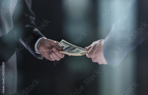 Money transfer between colleagues on a black background