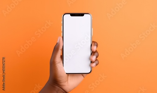 Black hand holding phone isolated on orange background. Blank screen, phone screen mockup, front view, clipping path, clipping mask.