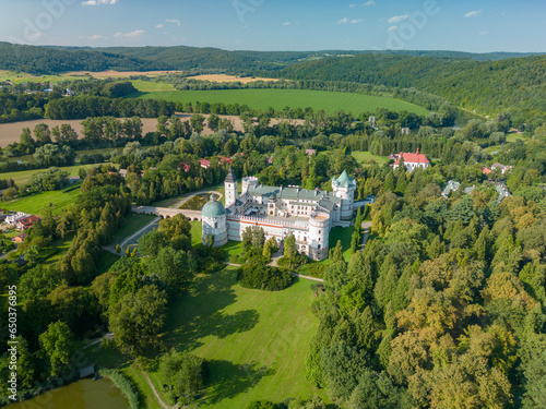Krasiczyn, Subcarpathian, Poland - 21 August 2023: Renaissance palace complex in Krasiczyn with adjacent English park. Landscape of Przemyśl Foothills and San River valley visible in the background photo