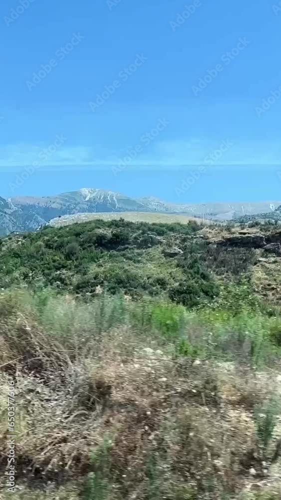 view from the window of the mountains of Albania passing vehicles on the road light cloudy sky summer. route travel trip view from the window of the mountains of Albania passing vehicles on the road light cloudy sky summer. route travel trip