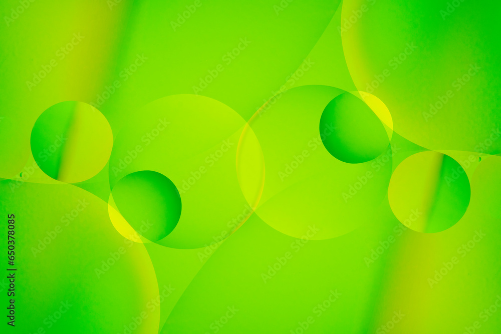 Macro photo with circles oil droplets water surface. Abstract green and yellow background with oil bubbles. Macro photo with circles oil droplets water surface. Abstract green and yellow background with oil bubbles.