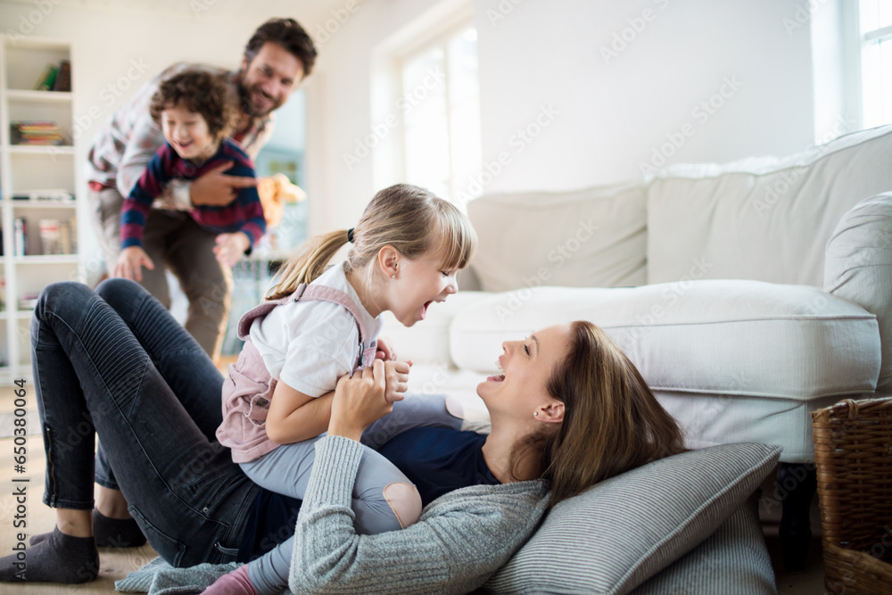 Young family playing with each other and having fun in the living room at home Young family playing with each other and having fun in the living room at home
