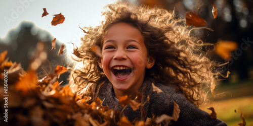 young girl jumping into a pile of leaves, joy emotion
