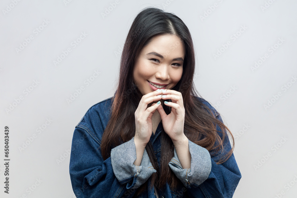 Portrait of mysterious brunette woman in blue denim jacket has interesting plan in mind, intention doing something, everything goes according scheme. Indoor studio shot isolated on gray background. Portrait of mysterious brunette woman in blue denim jacket has interesting plan in mind, intention doing something, everything goes according scheme. Indoor studio shot isolated on gray background.