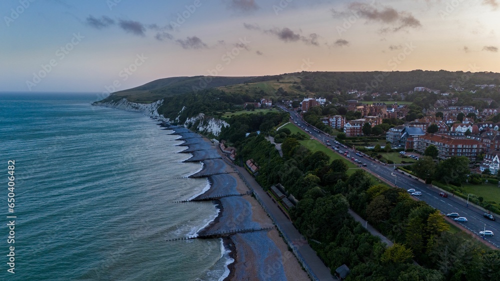 Aerial view of houses near a road along the sea in England at sunset
