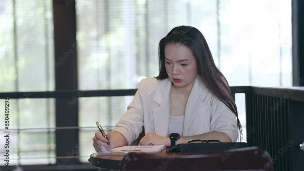 Financial analyst Asian Woman calculate Budget on Financial planning and making notes at home Financial analyst Asian Woman calculate Budget on Financial planning and making notes at home