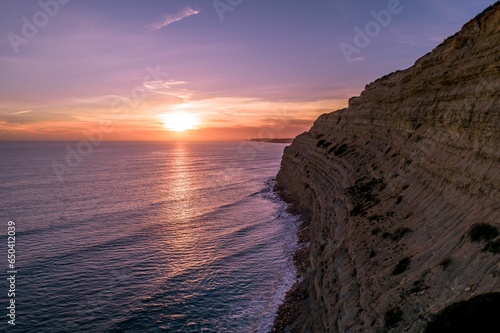 a beautiful sunset over the ocean with a couple waves coming