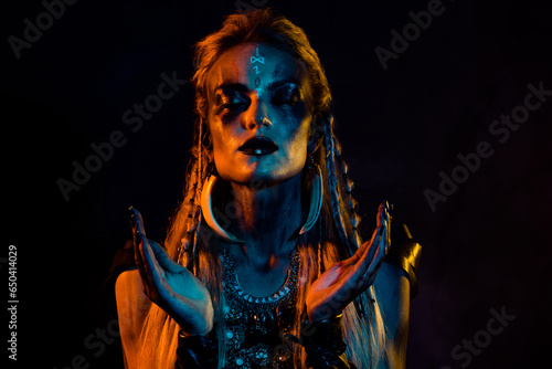 Photo of scandinavian mythology viking shaman girl bodyart pray oden ritual isolated on black background