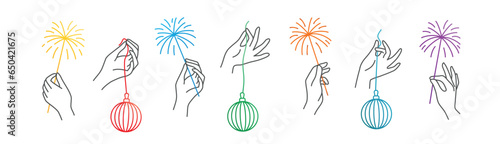 Hands holding a sparkling sparklers and Christmas tree balls.