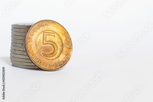 Closeup of a golden Slovenian Tolar coin on a white background photo