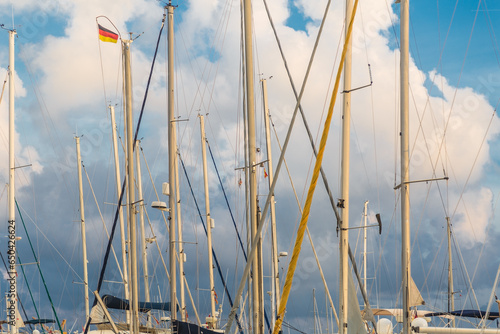 White boat and yacht masts with rigging on a blue sky background