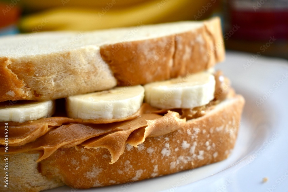 Peanut butter and banana sandwich on a white plate 