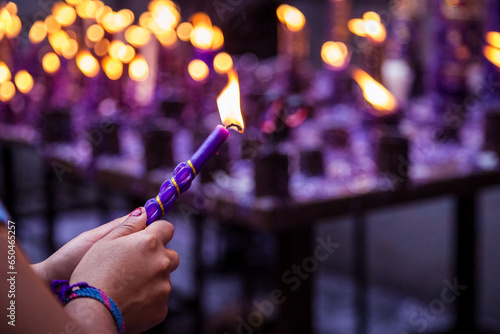Hand of an unknown person holding a candle with his hand for the festival of the Lord of Miracles in Lima, Peru